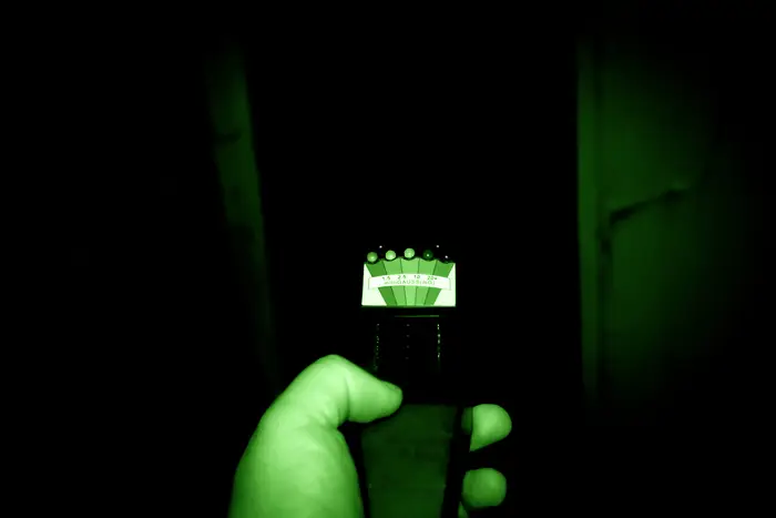 With green night vision, a hand hold a K2 meter